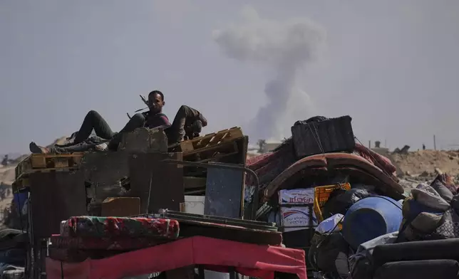 Smoke rises in the background following Israeli bombardment as displaced Palestinians flee northern Gaza, Tuesday, Sept. 16, 2025, after Israel's military says its expanded operation in Gaza City has begun and warns residents to leave. (AP Photo/Abdel Kareem Hana)