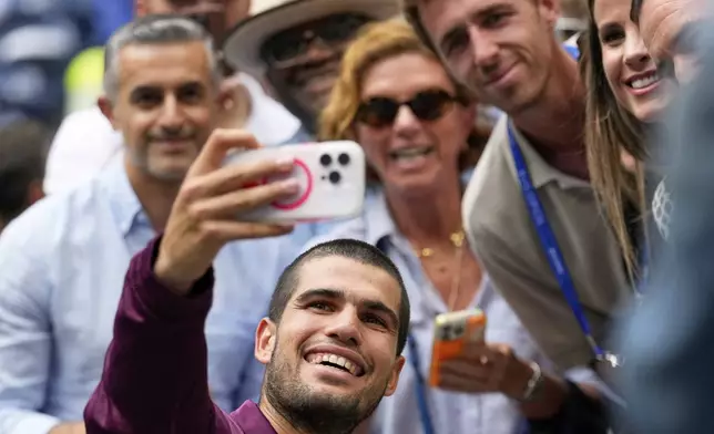 Carlos Alcaraz, of Spain, takes a seflie after defeating Novak Djokovic, of Serbia, during the men's singles semifinals of the U.S. Open tennis championships, Friday, Sept. 5, 2025, in New York. (AP Photo/Seth Wenig)