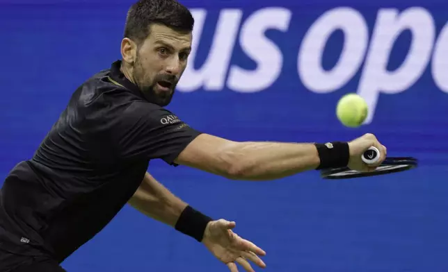 Novak Djokovic, of Serbia, returns a shot against Taylor Fritz, of the United States, during the quarterfinal round of the U.S. Open tennis championships, Tuesday, Sept. 2, 2025, in New York. (AP Photo/Adam Hunger)