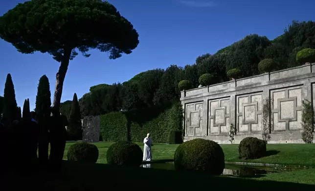 Pope Leo XIV feeds fishes of a pond during the inauguration of the "Borgo Laudato Si'" Advanced Training Center, at the papal summer residence in Castel Gandolfo, Italy, Friday Sept. 5, 2025. (Filippo Monteforte, Pool via AP)