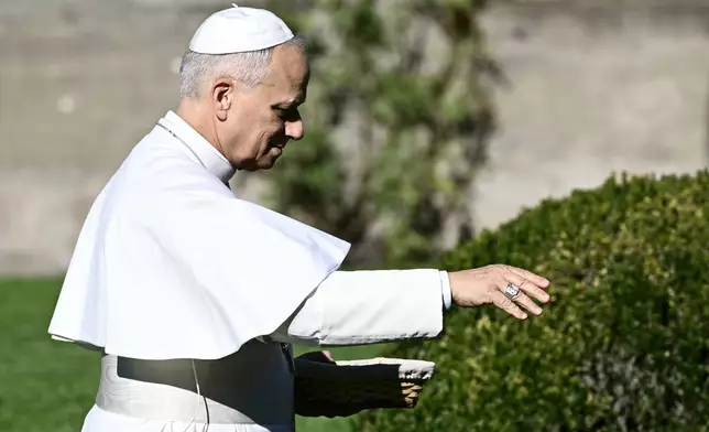 Pope Leo XIV feeds fishes of a pond during the inauguration of the "Borgo Laudato Si'" Advanced Training Center, at the papal summer residence in Castel Gandolfo, Italy, Friday Sept. 5, 2025. (Filippo Monteforte, Pool via AP)