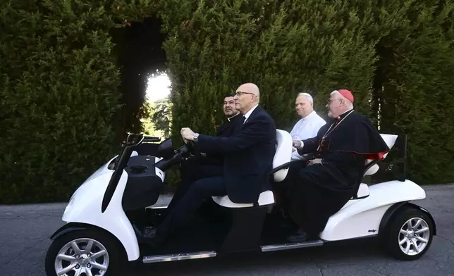 Pope Leo XIV, second from right, sits on an electric car during a tour for the inauguration of the "Borgo Laudato Si'" Advanced Training Center, at the papal summer residence in Castel Gandolfo, Italy, Friday Sept. 5, 2025. (Filippo Monteforte, Pool via AP)