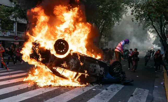 FILE PHOTO GALLERY - A police car goes up in flames, set on fire during a protest led by soccer fans in support of retirees demanding higher pensions and opposing austerity measures implemented by Javier Milei's government, in Buenos Aires, Argentina, March 12, 2025. (AP Photo/Rodrigo Abd, File)