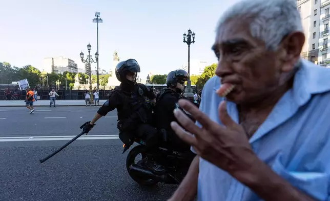 FILE PHOTO GALLERY - A protester’s dentures fly out of his mouth while running for cover as police on motorcycle work to disperse a demonstration of retirees demanding higher pensions, in Buenos Aires, Argentina, March 5, 2025. (AP Photo/Rodrigo Abd)