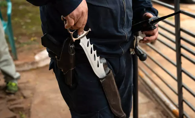 FILE PHOTO GALLERY - A prison security guard shows the knife he keeps on his person as he patrols outside the Regional Penitentiary in Villarica, Paraguay, Aug. 31, 2024. (AP Photo/Rodrigo Abd)