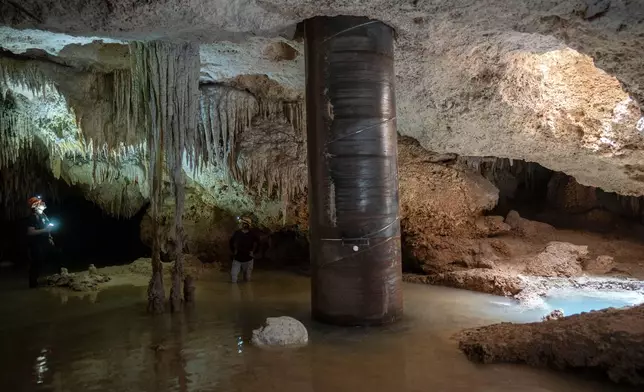 FILE PHOTO GALLERY - Biologist Roberto Rojo, left, observes stalactites near a steel pillar filled with concrete that was installed inside the Aktun Tuyul cave system to support the Maya Train track, on the outskirts of Playa del Carmen, Mexico, March 8, 2024. (AP Photo/Rodrigo Abd)