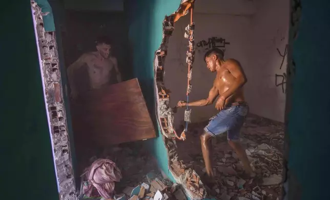 FILE PHOTO GALLERY - Neighbors and relatives of an 11-year-old boy who was fatally shot during a birthday party, destroy the home of the suspected gunman amid anger over escalating drug violence in Los Pumitas neighborhood of Rosario, Argentina, March 6, 2023. (AP Photo/Rodrigo Abd)