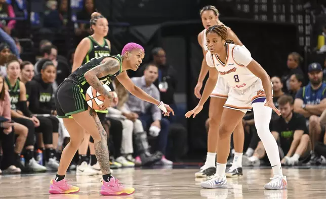 Minnesota Lynx guard Courtney Williams, left, directs traffic as Phoenix Mercury guard Monique Akoa Makani (8) defends during the first half of Game 1 of a WNBA basketball playoff semifinals series Sunday, Sept. 21, 2025, in Minneapolis. (AP Photo/Craig Lassig)