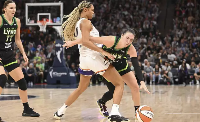 Minnesota Lynx forward Bridget Carleton, right, collides with Phoenix Mercury forward Satou Sabally (0) during the second half of Game 1 of a WNBA basketball playoff semifinals series Sunday, Sept. 21, 2025, in Minneapolis. (AP Photo/Craig Lassig)