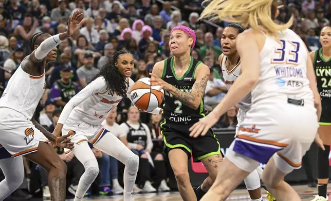 Minnesota Lynx guard Natisha Hiedeman (2) drives to the basket past a group of Phoenix Mercury defenders during the second half of Game 1 of a WNBA basketball playoff semifinals series Sunday, Sept. 21, 2025, in Minneapolis. (AP Photo/Craig Lassig)