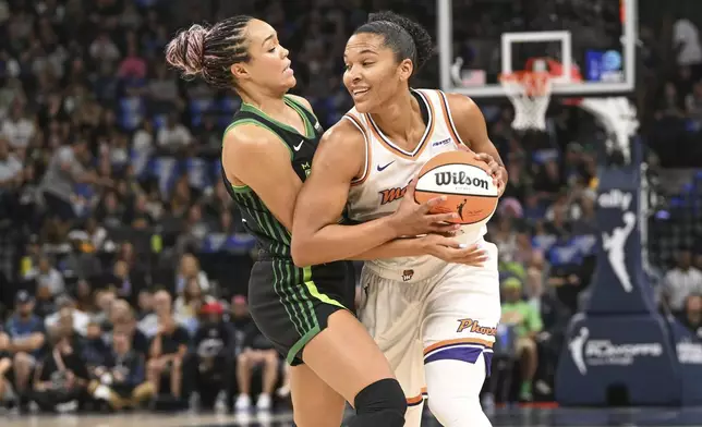 Phoenix Mercury forward Alyssa Thomas, right, tries to drive past Minnesota Lynx forward Napheesa Collier, left, during the first half of Game 1 of a WNBA basketball playoff semifinals series Sunday, Sept. 21, 2025, in Minneapolis. (AP Photo/Craig Lassig)
