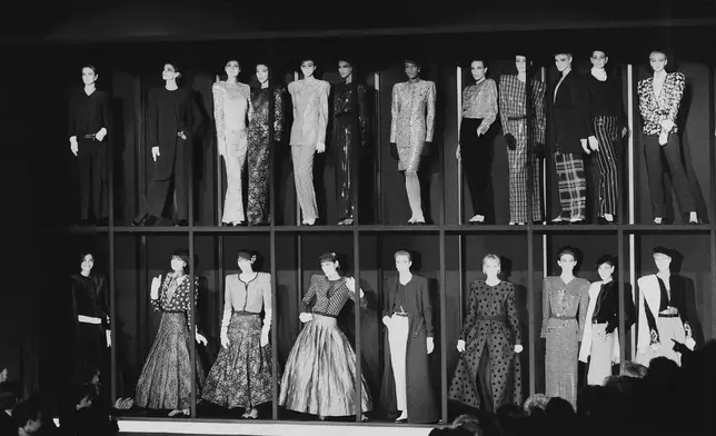 FILE - Models presenting the Giorgio Armani fashion collection stand in showcases at the end of the showing for Fall-Winter 1985-86 in Milan, March 13, 1985. (AP Photo/Ferdinando Meazza, file)