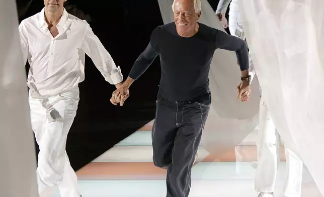 FILE - Fashion designer Giorgio Armani, center, runs on the catwalk as he acknowledges the applause of the audience after presenting the Emporio Armani Spring/Summer 2005 collection, in Milan, Italy, Sept. 27, 2004. (AP Photo/Luca Bruno, File)