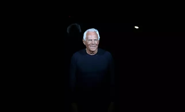 FILE - Italian fashion designer Giorgio Armani acknowledges applause at the end of his Emporio Armani men's Fall-Winter 2014 collection, part of the Milan Fashion Week, unveiled in Milan, Italy, Jan. 13, 2014. (AP Photo/Antonio Calanni, file)
