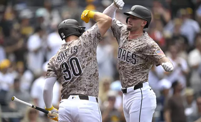 San Diego Padres' Jackson Merrill, right, celebrates with Gavin Sheets (30) after hitting a three-run home run against the Colorado Rockies during the second inning of a baseball game Sunday, Sept. 14, 2025, in San Diego. (AP Photo/Orlando Ramirez)