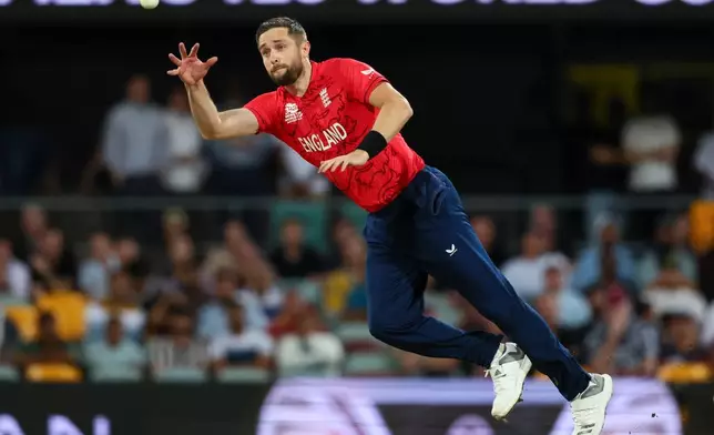FILE - England's Chris Woakes fields the ball off this own bowling during the T20 World Cup cricket match between England and New Zealand in Brisbane, Australia, Tuesday, Nov. 1, 2022. (AP Photo/Tertius Pickard, File)