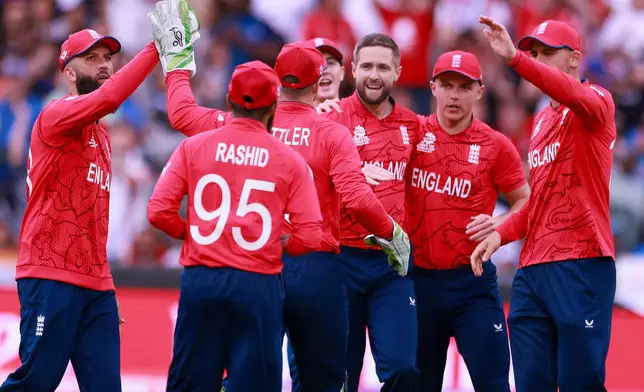 FILE - England's Chris Woakes, centre, is congratulated by teammates after talking the wicket of India's KL Rahul during the T20 World Cup cricket semifinal between England and India in Adelaide, Australia, Thursday, Nov. 10, 2022. (AP Photo/James Elsby, File)