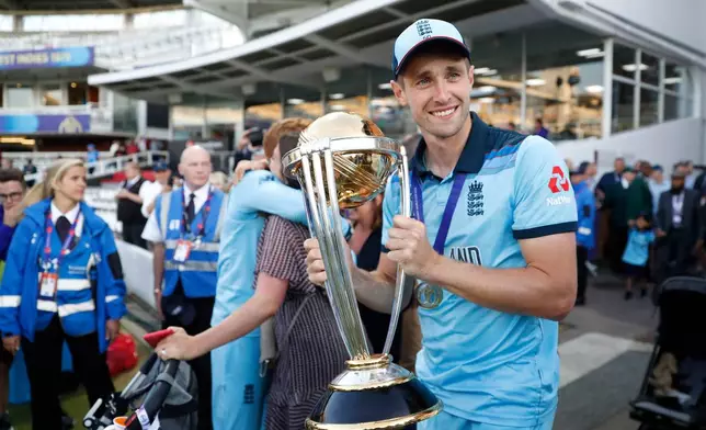 FILE - England's Chris Woakes holds the trophy as he celebrates after winning the Cricket World Cup final match between England and New Zealand at Lord's cricket ground in London, Sunday, July 14, 2019. (AP Photo/Alastair Grant, File)