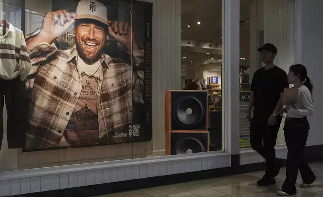 Shoppers walk by an ad featuring Kansas City Chiefs' Travis Kelce outside an American Eagle Outfitters, Thursday, Sept. 4, 2025, in Bellevue, Wash. (AP Photo/Lindsey Wasson)
