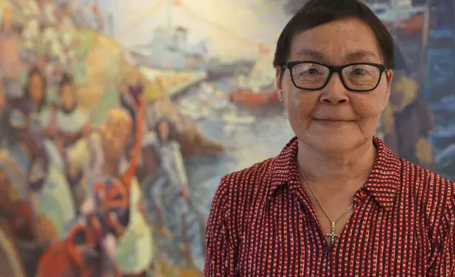 52-year-old retiree Katrine Petersen poses for a photo in front of a painting at The Greenlandic House in central Copenhagen, Denmark, Sept. 19, 2025. (AP Photo/James Brooks)