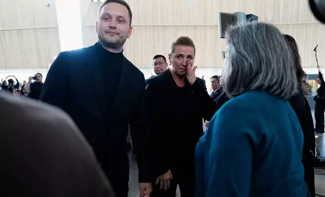 Greenland's Prime Minister Jens-Frederik Nielsen, left, and Danish Prime Minister Mette Frederiksen, center, greet and apologize to the affected women after a meeting in the cultural house Katuaq in Nuuk, Greenland, Wednesday Sept. 24, 2025. (Mads Claus Rasmussen/Ritzau Scanpix via AP)