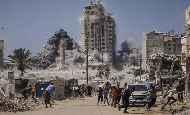 FILE - Palestinians run for cover during an Israeli airstrike on a high-rise building in Gaza City, Sept. 5, 2025, after the Israeli army issued a warning. (AP Photo/Yousef Al Zanoun, File)