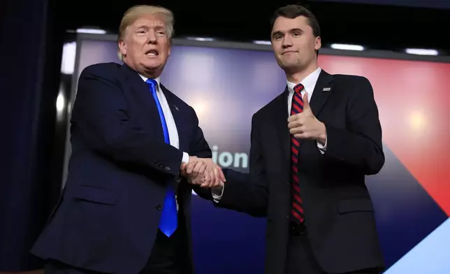 FILE - President Donald Trump shakes hands with moderator Charlie Kirk, during a Generation Next White House forum at the Eisenhower Executive Office Building on the White House complex in Washington, Thursday, March 22, 2018. (AP Photo/Manuel Balce Ceneta, File)