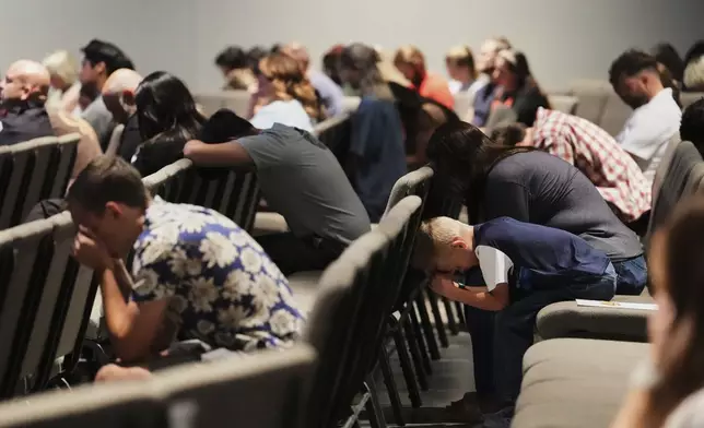 Congregants bow their heads during a prayer event at CenterPoint Church the day after Charlie Kirk, the CEO and co-founder of Turning Point USA was shot and killed, Thursday, Sept. 11, 2025, in Orem, Utah. (AP Photo/Lindsey Wasson)