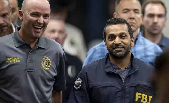 Utah Gov. Spencer Cox, left, and FBI Director Kash Patel, right, converse as they make their way to a press conference to speak to media about the shooting death of Charlie Kirk at Utah Valley University in Orem, Utah, on Thursday, Sept. 11, 2025. (Rio Giancarlo/The Deseret News via AP)