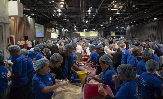 Volunteers work during the "NYC Meal Pack For 9/11 Day" at the Intrepid Sea, Air &amp; Space Museum, Wednesday, Sep. 10, 2025, in New York. (AP Photo/Yuki Iwamura)