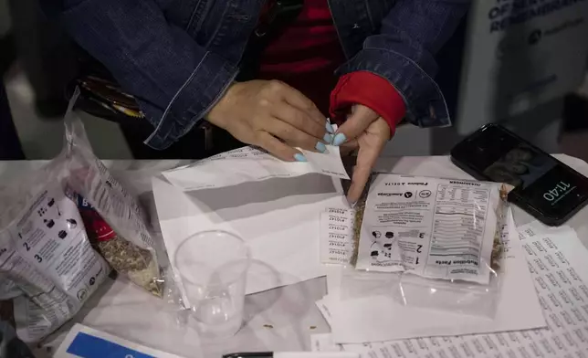 A volunteer puts labels on the bag during the "NYC Meal Pack For 9/11 Day" at the Intrepid Sea, Air &amp; Space Museum, Wednesday, Sep. 10, 2025, in New York. (AP Photo/Yuki Iwamura)