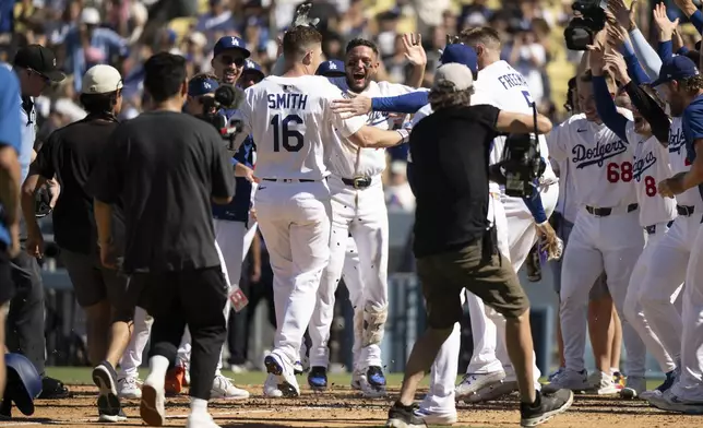 Los Angeles Dodgers' Will Smith (16) celebrates after his walkoff solo home run with teammates during the ninth inning of a baseball game against the Arizona Diamondbacks in Los Angeles, Sunday, Aug. 31, 2025. (AP Photo/Kyusung Gong)