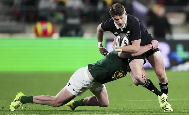 All Blacks Beauden Barrett, right, is tackled by South Africa's Ethan Hooker during their Rugby Championship test match in Wellington, New Zealand, Saturday, Sept. 13, 2025. (AP Photo/Marty Melville)