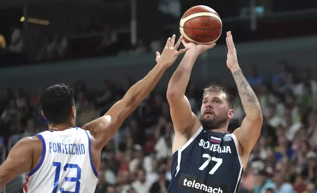 Slovenia's Luka Doncic tries to shoot while defended by Italy's Simone Fontecchio during the Eurobasket, European Basketball Championship round of 16 match between Italy and Slovenia at the Riga Arena in Riga, Latvia, Sunday, Sept. 7, 2025. (AP Photo/Sergei Grits)