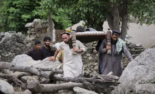 An injured person is carried to a military helicopter that landed to evacuate injured victims of an earthquake that killed many people and destroyed villages in eastern Afghanistan, in Mazar Dara, Kunar province, Monday, Sept. 1, 2025. (AP Photo/Wahidullah Kakar)