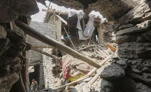 A local resident walks through a partially collapsed house in an area devastated by Sunday's powerful 6.0-magnitude earthquake that killed many people and destroyed villages in eastern Afghanistan, in Dara Noor, Kunar province, Tuesday, Sept. 2, 2025,. (AP Photo/Wahidullah Kakar)