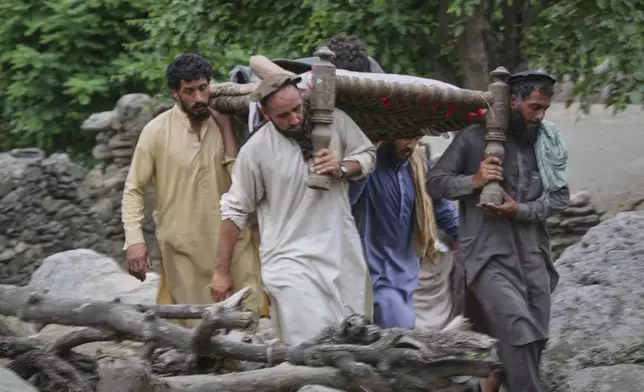 An injured person is carried to a military helicopter that landed to evacuate injured victims of an earthquake that killed many people and destroyed villages in eastern Afghanistan, in Mazar Dara, Kunar province, Monday, Sept. 1, 2025. (AP Photo/Wahidullah Kakar)