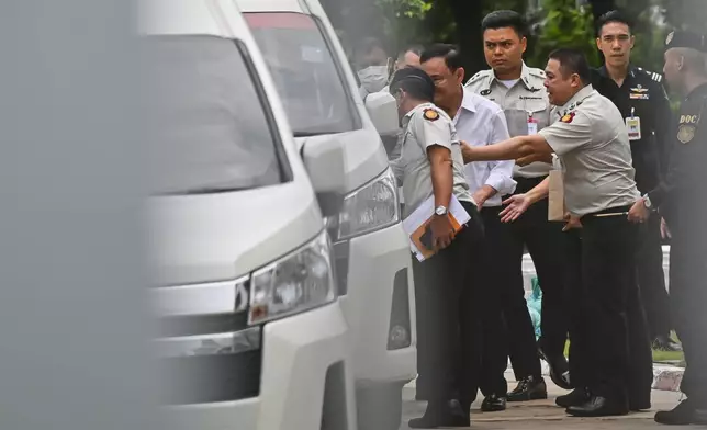 Thailand's former Prime Minister Thaksin Shinawatra, second from left, leaves the Supreme Court for Bangkok Remand Prison in Bangkok, Thailand, Tuesday, Sept. 9, 2025. (AP Photo/Panumas Sanguanwong)