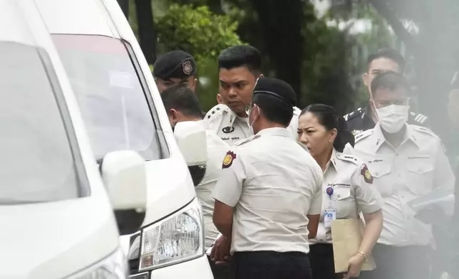Thailand's former Prime Minister Thaksin Shinawatra, partly seen at left, leaves the Supreme Court for Bangkok Remand Prison in Bangkok, Thailand, Tuesday, Sept. 9, 2025, (AP Photo/Sakchai Lallit)