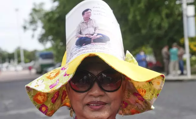 A supporter of Thailand's former Prime Minister Thaksin Shinawatra wears a hat with his image on, outside the Supreme Court in Bangkok, Thailand, Tuesday, Sept. 9, 2025, (AP Photo/Sakchai Lalit)