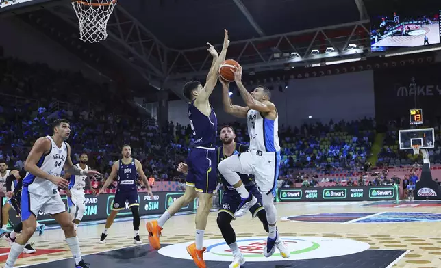 Greece's Kostas Sloukas, left, shoots next to Bosnia's Amar Gegic during the Eurobasket, European Basketball Championship Group C match between Greece and Bosnia at Spyros Kyprianou Arena, in Limassol, Cyprus, Tuesday, Sept. 2, 2025. (AP Photo/Chara Savvidou)