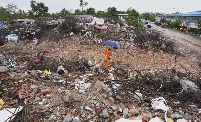 A fire officer works at the site of the Sky Villa, a 10-story condo that collapsed during the March 28 earthquake, in Mandalay, Myanmar, Wednesday, Aug. 27, 2025. (AP Photo/Aung Shine Oo)