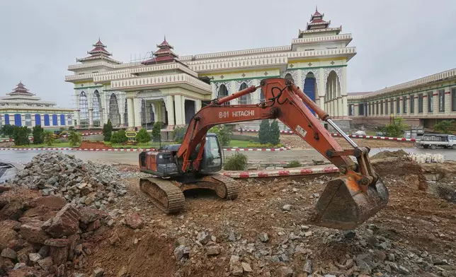 A backhoe clears an area near the parliament building that was damaged in the March 28 earthquake in Naypyitaw, Myanmar, Thursday, Aug. 28, 2025. (AP Photo/Aung Shine Oo)