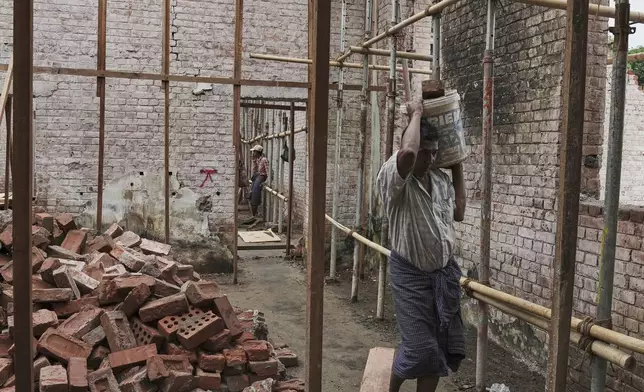 Laborers work at a building in the Mandalay University compound that was damaged in the March 28 earthquake, in Mandalay, Myanmar, Wednesday, Aug. 27, 2025. (AP Photo/Aung Shine Oo)