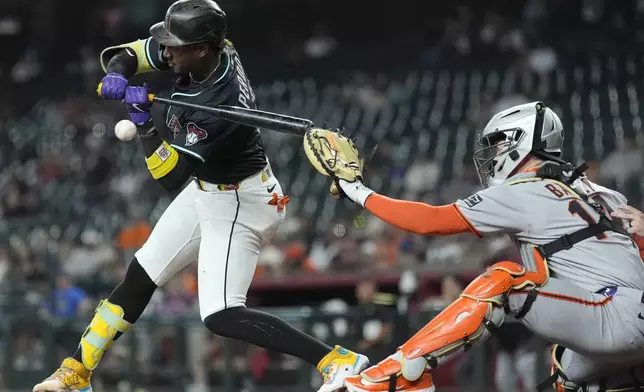 Arizona Diamondbacks' Geraldo Perdomo, left, checks his swing on a high pitch as San Francisco Giants catcher Patrick Bailey reaches for the ball during the first inning of a baseball game Wednesday, Sept. 17, 2025, in Phoenix. (AP Photo/Ross D. Franklin)