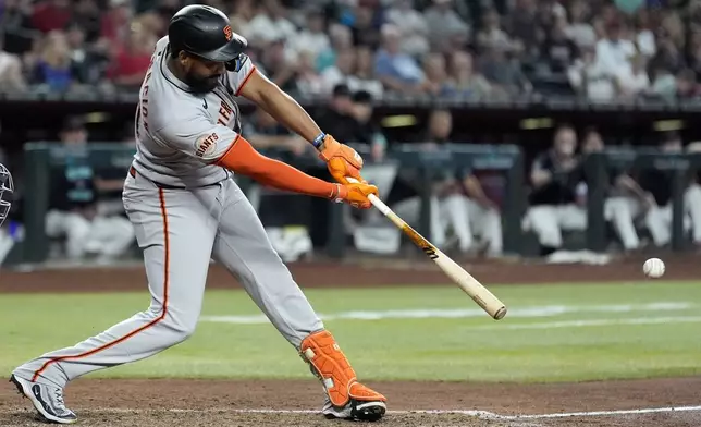 San Francisco Giants' Jerar Encarnacion connects for a run-scoring single against the Arizona Diamondbacks during the 11th inning of a baseball game Wednesday, Sept. 17, 2025, in Phoenix. (AP Photo/Ross D. Franklin)