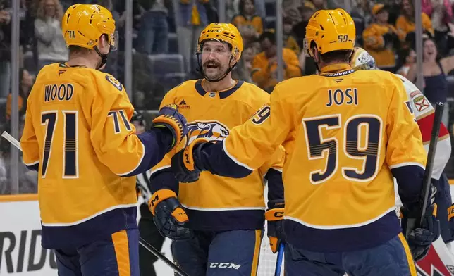 Nashville Predators left wing Filip Forsberg, center celebrates his goal with right wing Matthew Wood (71) and defenseman Roman Josi (59) during the second period of an NHL preseason hockey game against the Florida Panthers, Sunday, Sept. 21, 2025, in Nashville, Tenn. (AP Photo/George Walker IV)