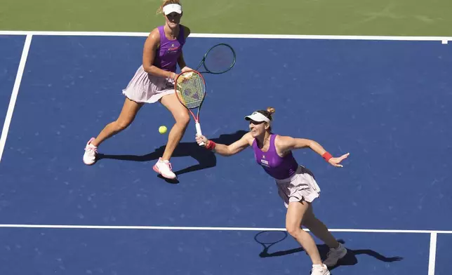 Gabriela Dabrowski, of Canada, right returns a shot to Taylor Townsend, of the United States, and Katerina Siniakova, of the Czech Republic, as partner Erin Routliffe, of New Zealand, looks on during the women's doubles final of the U.S. Open tennis championships, Friday, Sept. 5, 2025, in New York. (AP Photo/Seth Wenig)