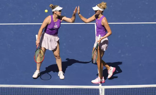 Gabriela Dabrowski, of Canada, and Erin Routliffe, of New Zealand, high five after a rally against Taylor Townsend, of the United States, and Katerina Siniakova, of the Czech Republic, during the women's doubles final of the U.S. Open tennis championships, Friday, Sept. 5, 2025, in New York. (AP Photo/Seth Wenig)