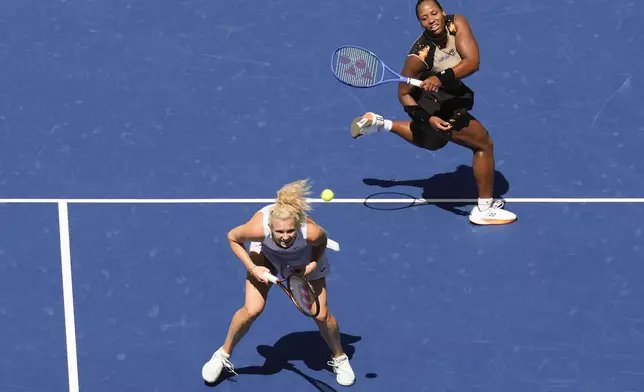Taylor Townsend, of the United States, returns a shot over Katerina Siniakova, of the Czech Republic, to Gabriela Dabrowski, of Canada, and Erin Routliffe, of New Zealand, during the women's doubles final of the U.S. Open tennis championships, Friday, Sept. 5, 2025, in New York. (AP Photo/Seth Wenig)